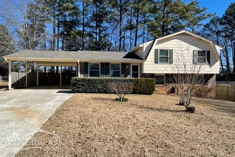 a white house with a driveway and a covered porch